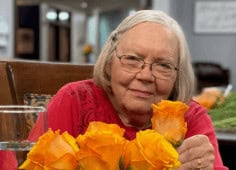Older Woman In Red Smiles At Camera